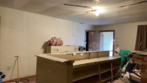 A worker breaking apart a counter during a demolition and debris removal job by Eagle Junk Removal in Fort Worth, TX.