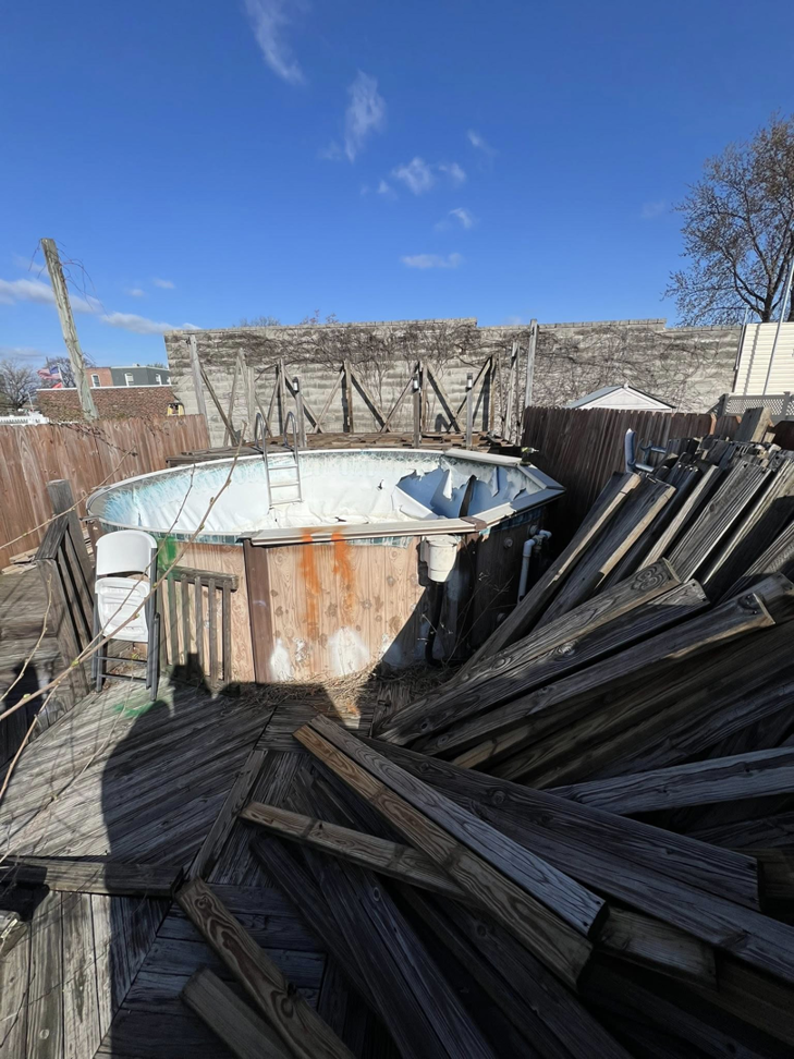 A dilapidated above-ground pool and broken wooden deck awaiting removal by Affordable Cleanouts LLC in Philadelphia, PA.
