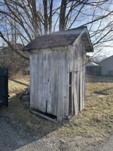 A dilapidated wooden shed, likely awaiting demolition and removal by Junk Removal of Hancock County in Indianapolis, IN.