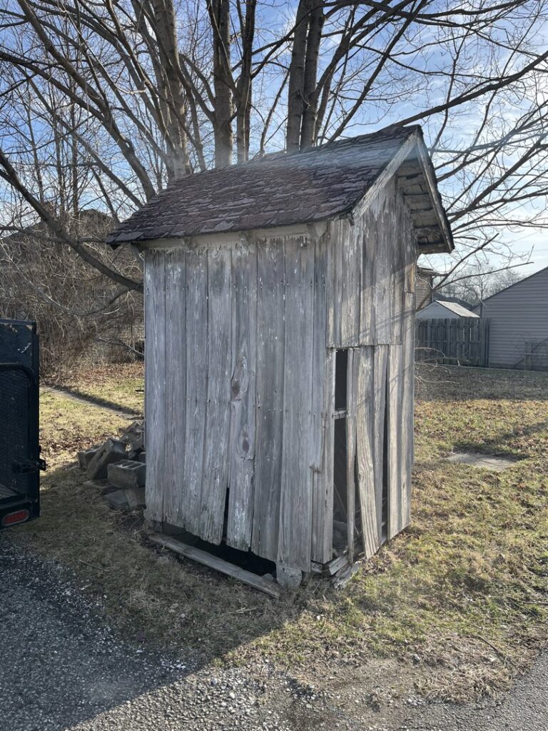 A dilapidated wooden shed, likely awaiting demolition and removal by Junk Removal of Hancock County in Indianapolis, IN.