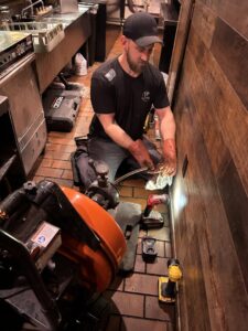 A drain cleaning machine positioned next to an outdoor cleanout, ready for service by JP Plumbing in Phoenix, AZ