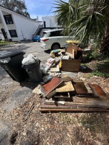 A pile of wood and general debris on a residential driveway for removal by Bring That Junk Removal and Demolition in Jacksonville, FL.