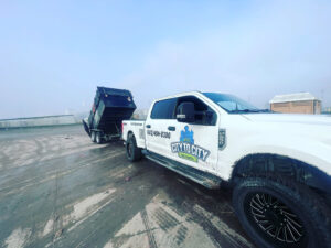 A City to City Junk Removal truck with a dump trailer, likely after a job, in Fort Worth, TX.