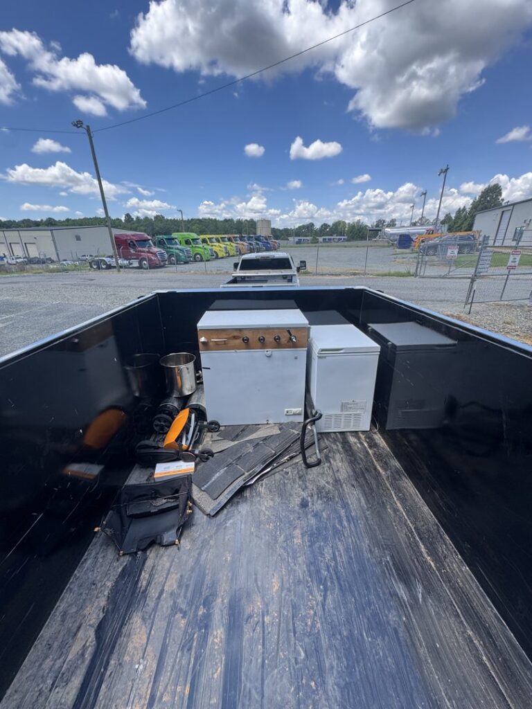 A dump trailer loaded with construction debris and wood scraps after a cleanup job by Junkjet in Charlotte, NC.