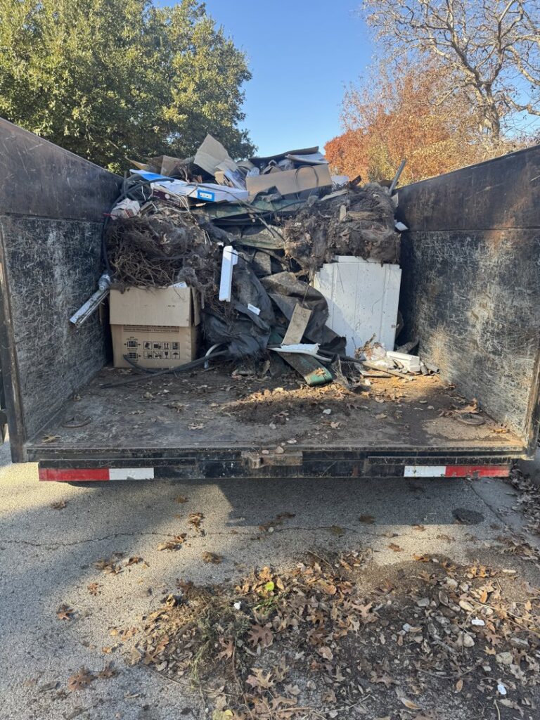 A large dump trailer completely filled with mixed junk and debris, collected by Eagle Junk Removal in Fort Worth, TX.