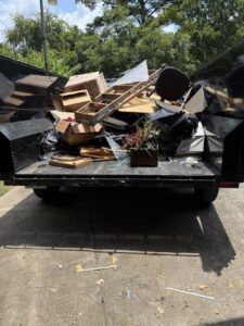 A dump trailer overflowing with household junk and debris, collected by Clutch City Junk Removal in Tomball, TX.