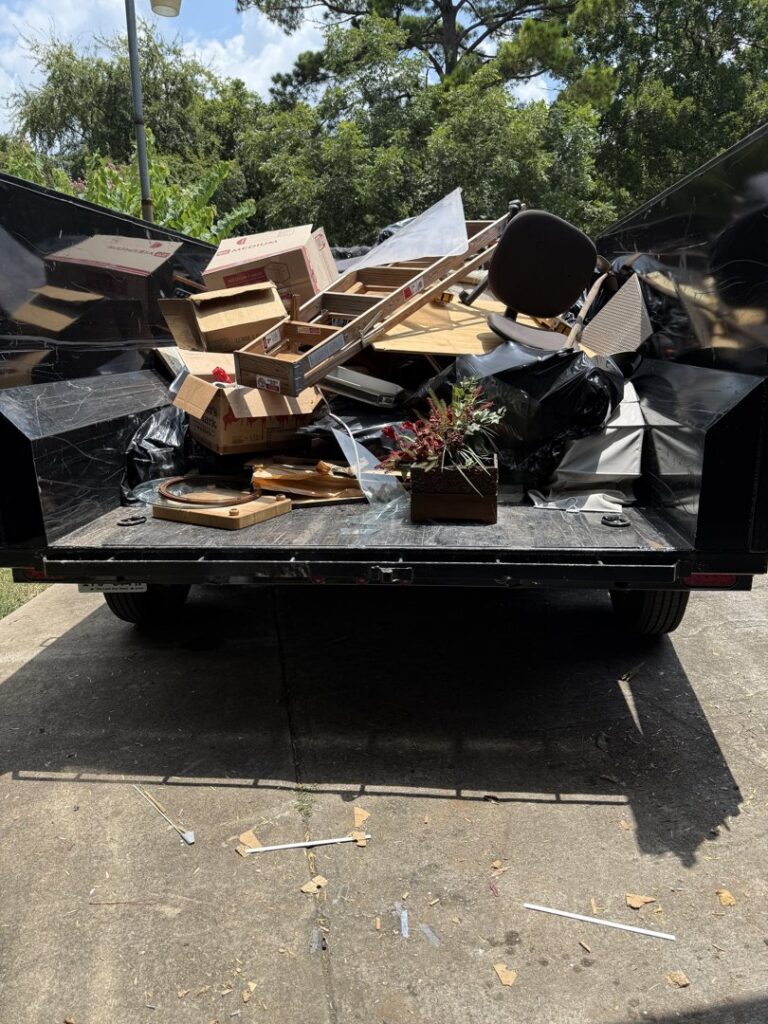 A dump trailer overflowing with household junk and debris, collected by Clutch City Junk Removal in Tomball, TX.