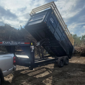 A dump trailer unloading a large pile of debris at a disposal site for McMillian Junk Removal in Houston, TX
