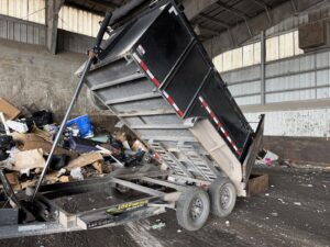 A dump trailer unloading a large amount of junk at a disposal facility for Bring That Junk Removal and Demolition in Jacksonville, FL.