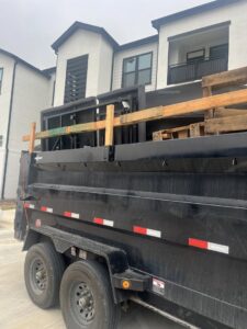 A dump trailer loaded with wooden pallets and debris for removal by Silverhull Junk Removal in San Antonio, TX.