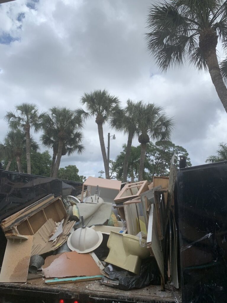 A dump truck filled with construction debris, including wood and old sinks, after a junk removal service by Zen Junk in San Jose, CA.