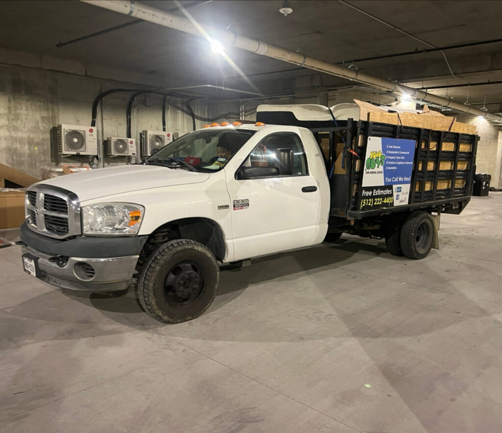 A JunkGuys Austin Junk Removal dump truck, loaded with items, parked in an underground garage after a service in Austin, TX.