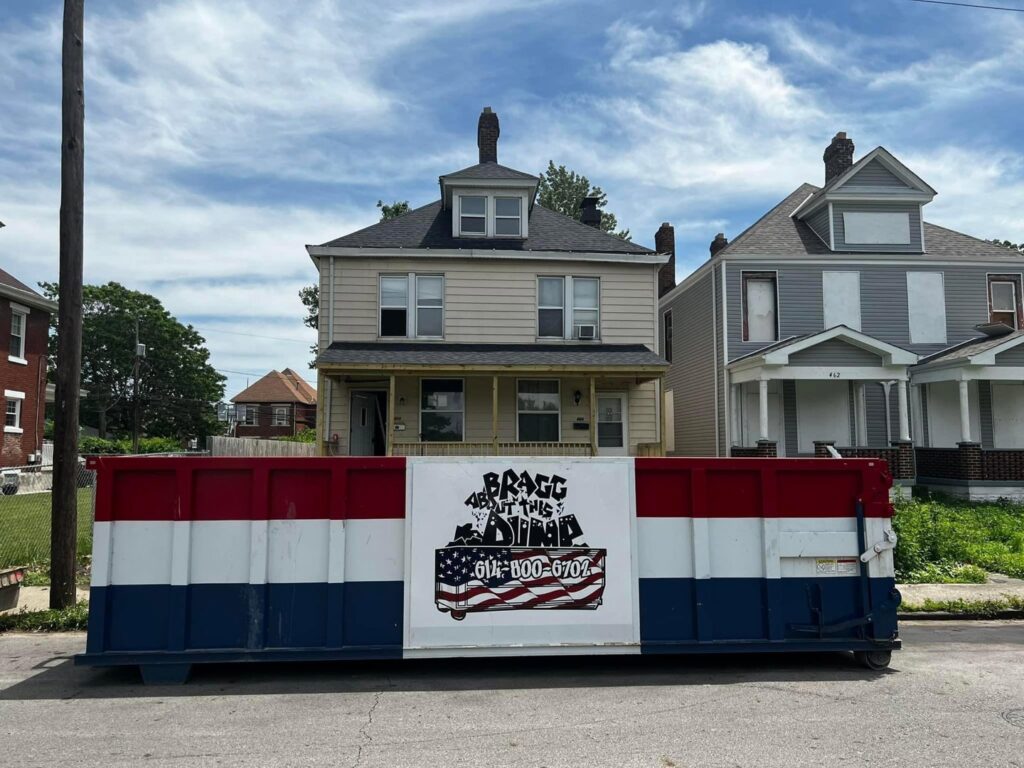 A branded dumpster from Bragg About This Dump placed on a residential street in Columbus, OH, for a home cleanout or renovation project.