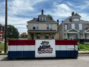 A branded dumpster from Bragg About This Dump placed on a residential street in Columbus, OH, for a home cleanout or renovation project.