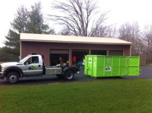 A Bin There Dump That truck with a green dumpster attached, ready for junk removal service in Indianapolis, IN.