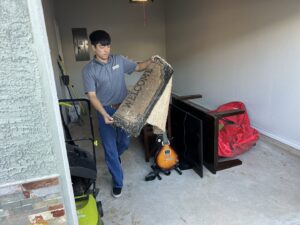 A Final Destination Junk Removal employee clearing out items during a garage cleanout service in San Antonio, TX.