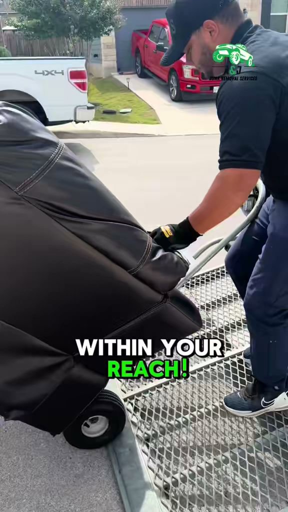 An A&J Removal Service employee loading a large, covered item onto a truck using a dolly in San Antonio, TX.