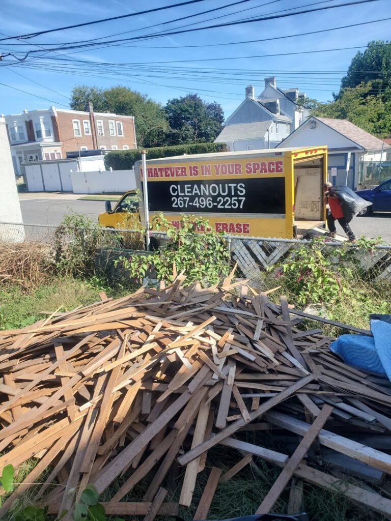 A Space Erasers Junk Removal employee loading wood debris into a truck during a cleanout job in Philadelphia, PA