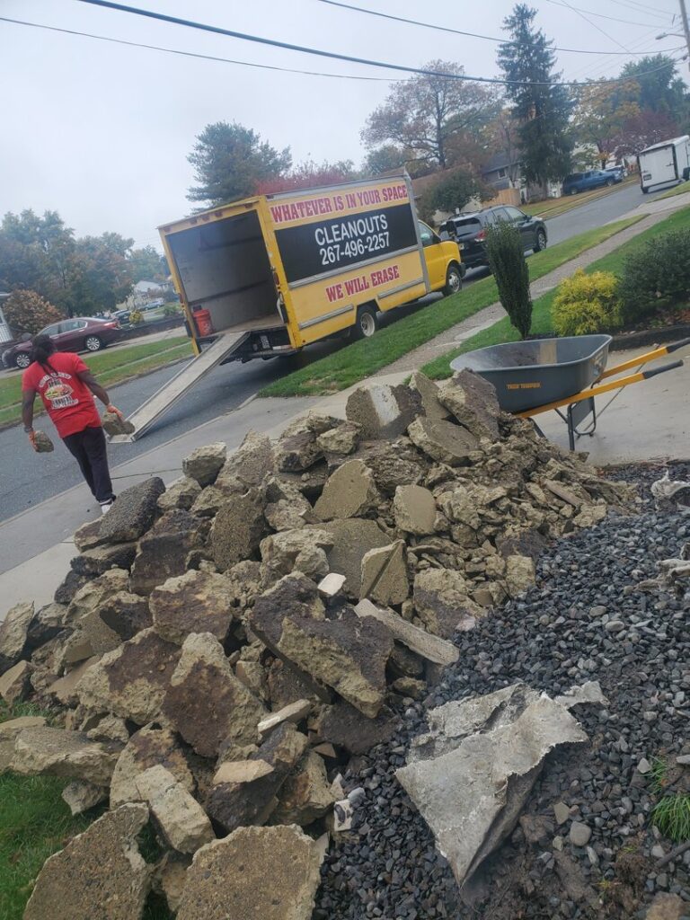 A Space Erasers Junk Removal employee removing concrete debris and loading it into a truck in Philadelphia, PA