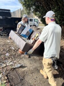 Two employees carrying a heavy sofa for junk removal by Lug Stars Junk Removal in Columbus, OH.