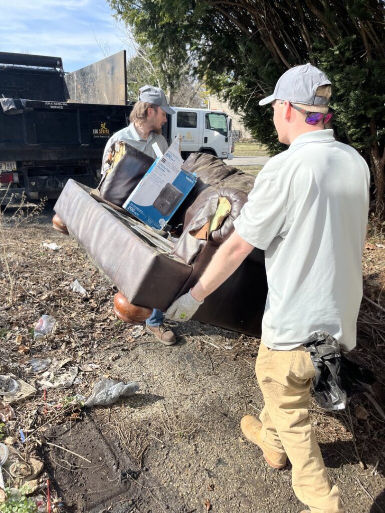 Two employees carrying a heavy sofa for junk removal by Lug Stars Junk Removal in Columbus, OH.