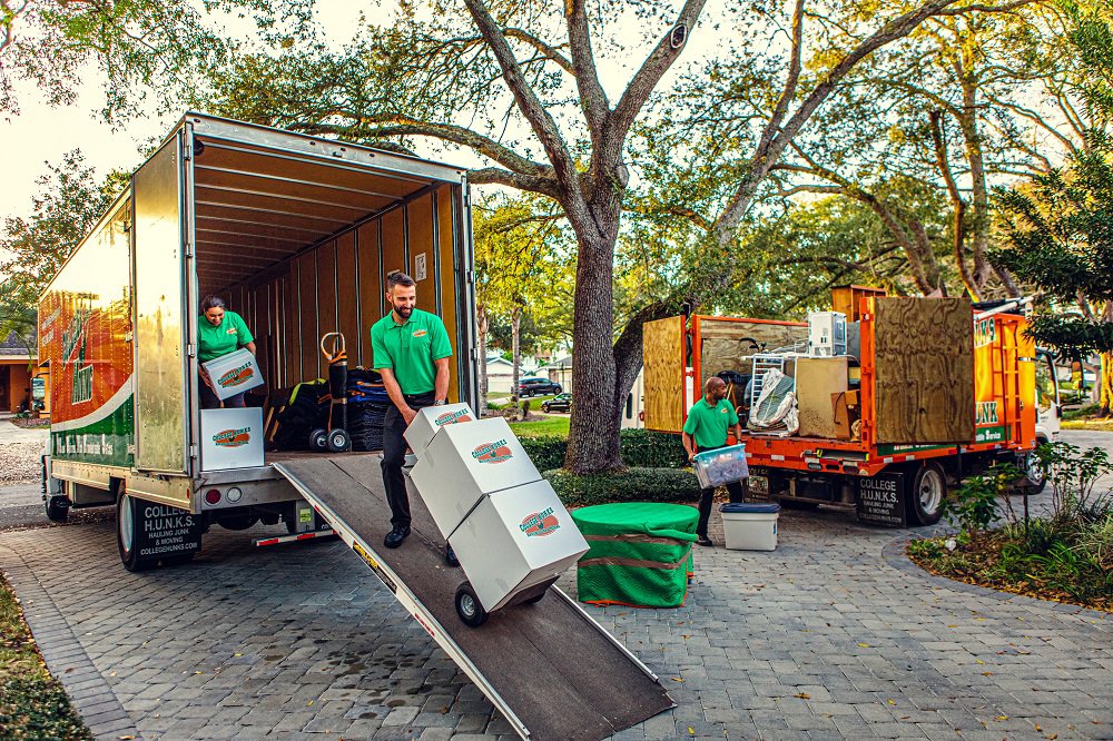 Employees loading items into a junk removal truck at College Hunks Hauling Junk and Moving in Jacksonville, FL