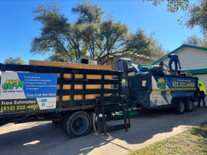 JunkGuys Austin Junk Removal employees are busy loading a truck and trailer with various items during a cleanout service in Austin, TX.