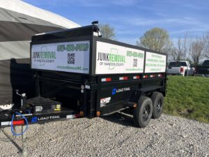 An empty dump trailer branded with Junk Removal of Hancock County, ready for service in Indianapolis, IN.
