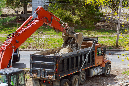 An excavator loading construction debris and rubble into a dump truck, showcasing a junk removal job by Epic Junk Removal SD in San Diego, CA.