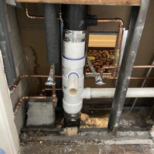 Exposed PVC drain pipes and copper water lines during a plumbing installation or repair by Tribeca Plumbing in Dallas, TX.