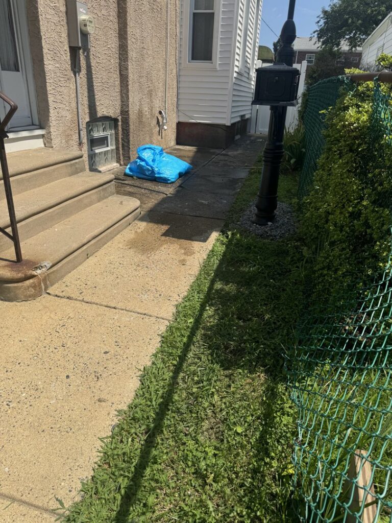 Various furniture pieces, including cabinets, doors, and suitcases, piled on a driveway for removal by High Speed Junk Removal in Levittown, PA.