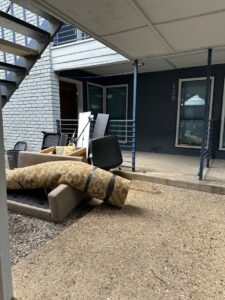 Discarded furniture and other items piled outside an apartment building, awaiting removal by Perez Junk Removal in Anaheim, CA.