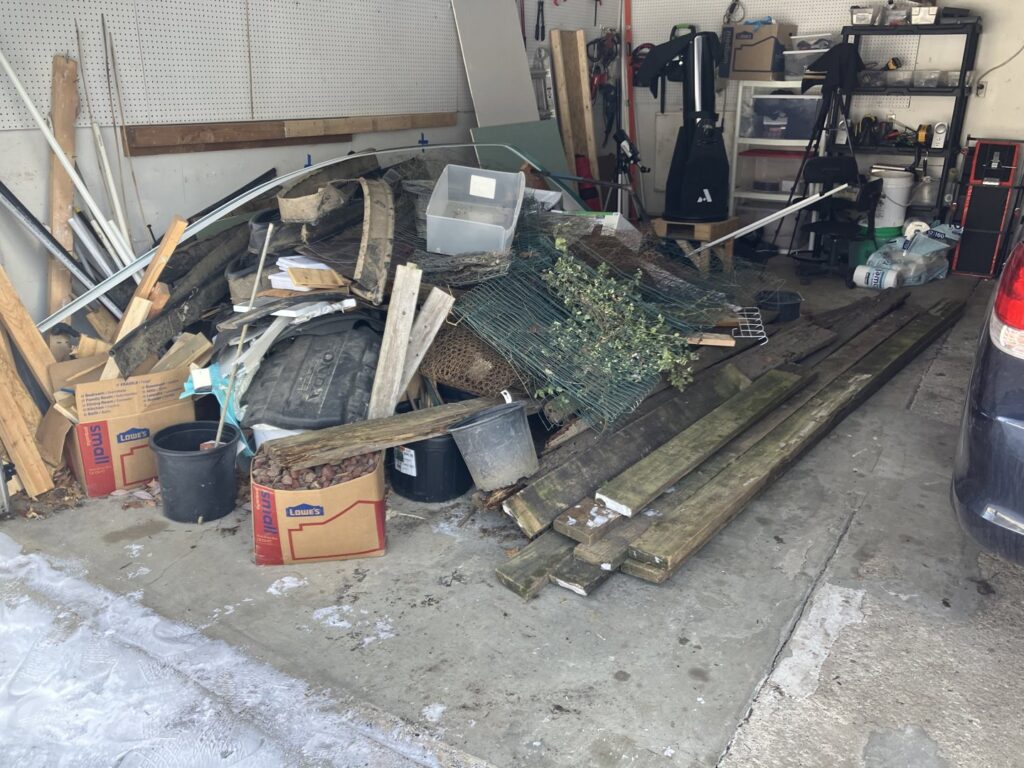 A cluttered garage with a large pile of junk and debris, ready for cleanout by We Haul It Cleaning Service LLC in Canal Winchester, OH.