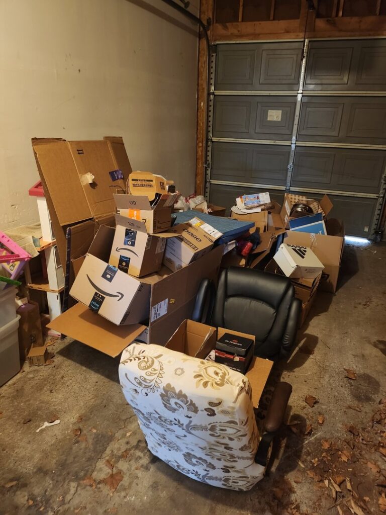 A garage packed with cardboard boxes and old office chairs, ready for junk removal by 2 Women with a Pickup Truck and Trailer Too LLC in Columbus, OH.