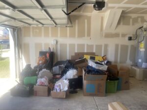 A garage packed with boxes, furniture, and miscellaneous junk, awaiting removal by Controlled Chaos Services in San Antonio, TX