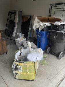 A garage filled with items like mattresses, bed frames, and trash cans, ready for junk removal by Cee J Junk Removal LLC in Phoenix, AZ.