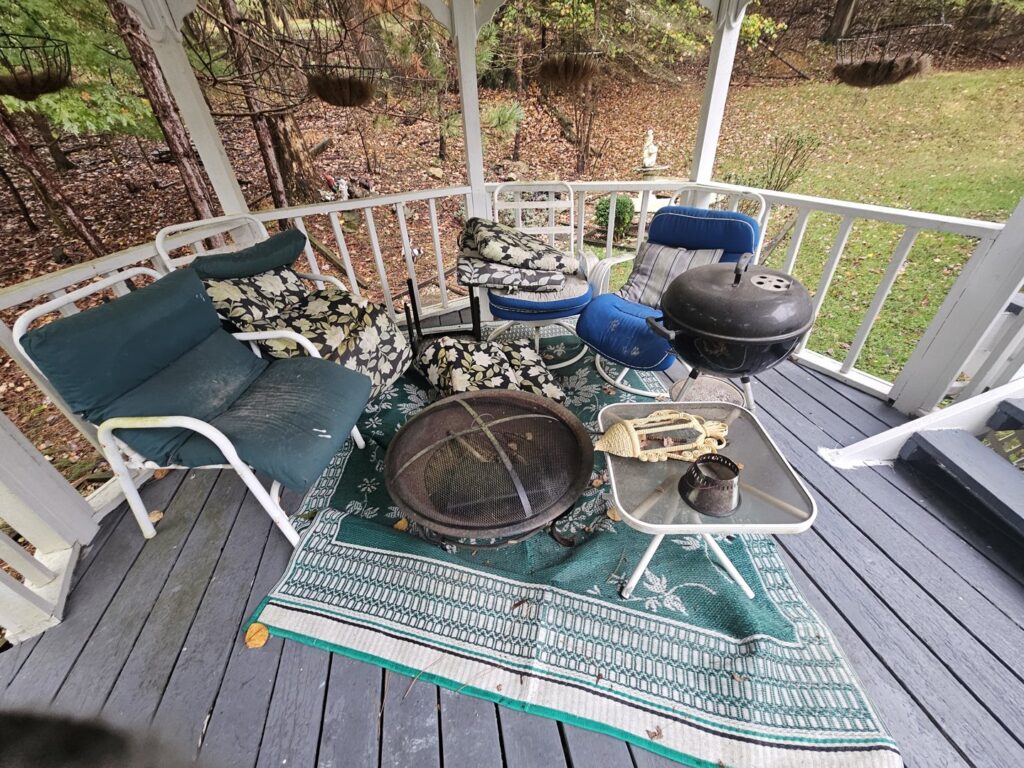 A gazebo filled with old outdoor furniture, a fire pit, and a grill, ready for junk removal by Purefoy's Professionals in Columbus, OH.