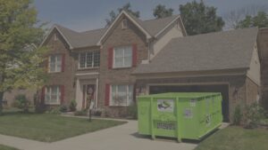 A bright green Bin There Dump That dumpster placed on a residential driveway in Indianapolis, IN, ready for general junk removal.