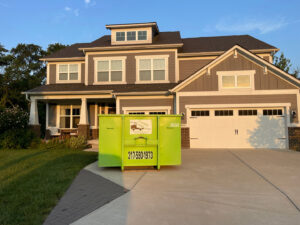 A Bin There Dump That green dumpster placed in front of a home for convenient junk removal services in Indianapolis, IN.