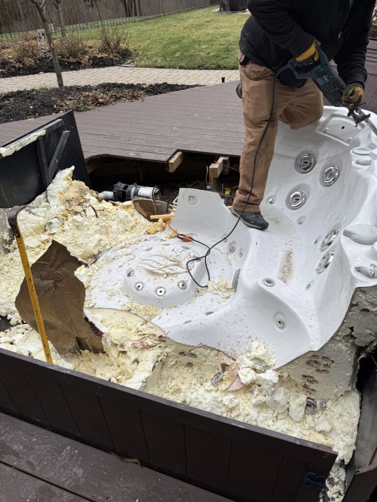 A worker cutting apart an old hot tub on a deck for removal by Master Junkers in Powell, OH.
