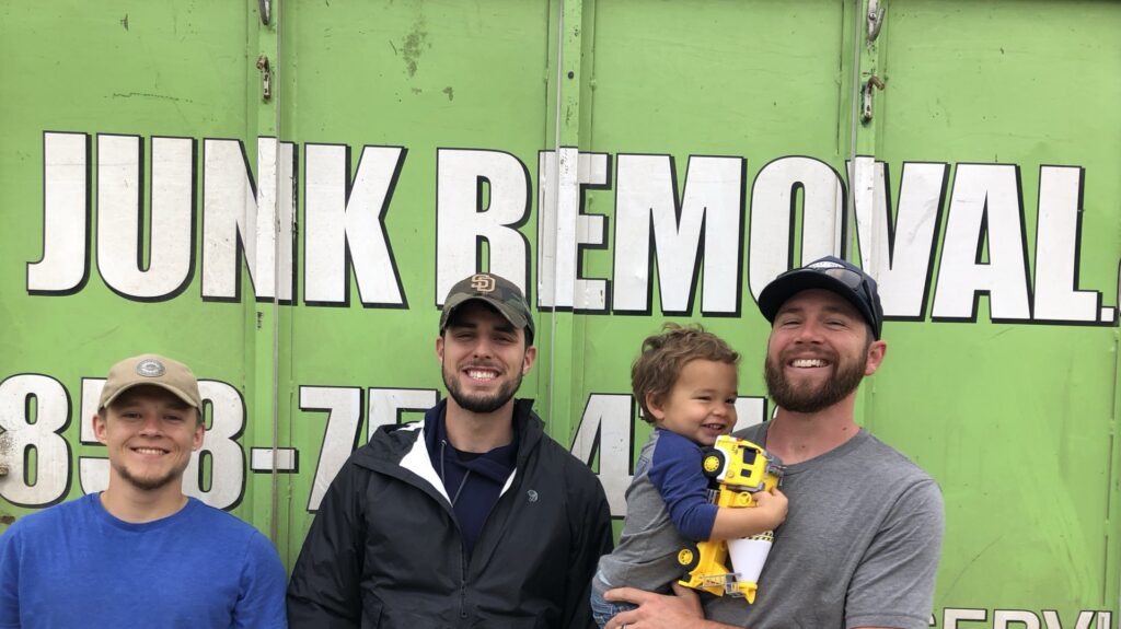 A Jake's Junk Removal truck fully loaded with various debris and household items in San Diego, CA.
