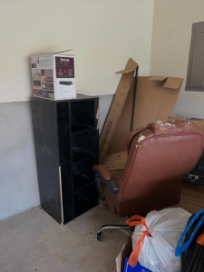 A pile of junk including a damaged office chair, shelving unit, and boxes ready for removal by Yellowstone Junk Removal in San Antonio, TX.