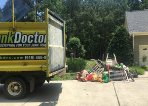 A large pile of household junk and debris on a driveway, ready for removal by Junk Doctors of Charlotte in Charlotte, NC.