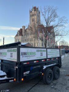 A Junk Removal of Hancock County trailer parked in front of a historic courthouse during winter in Indianapolis, IN.