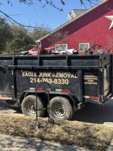 A junk removal trailer from Eagle Junk Removal in Fort Worth, TX, filled with furniture and construction debris.