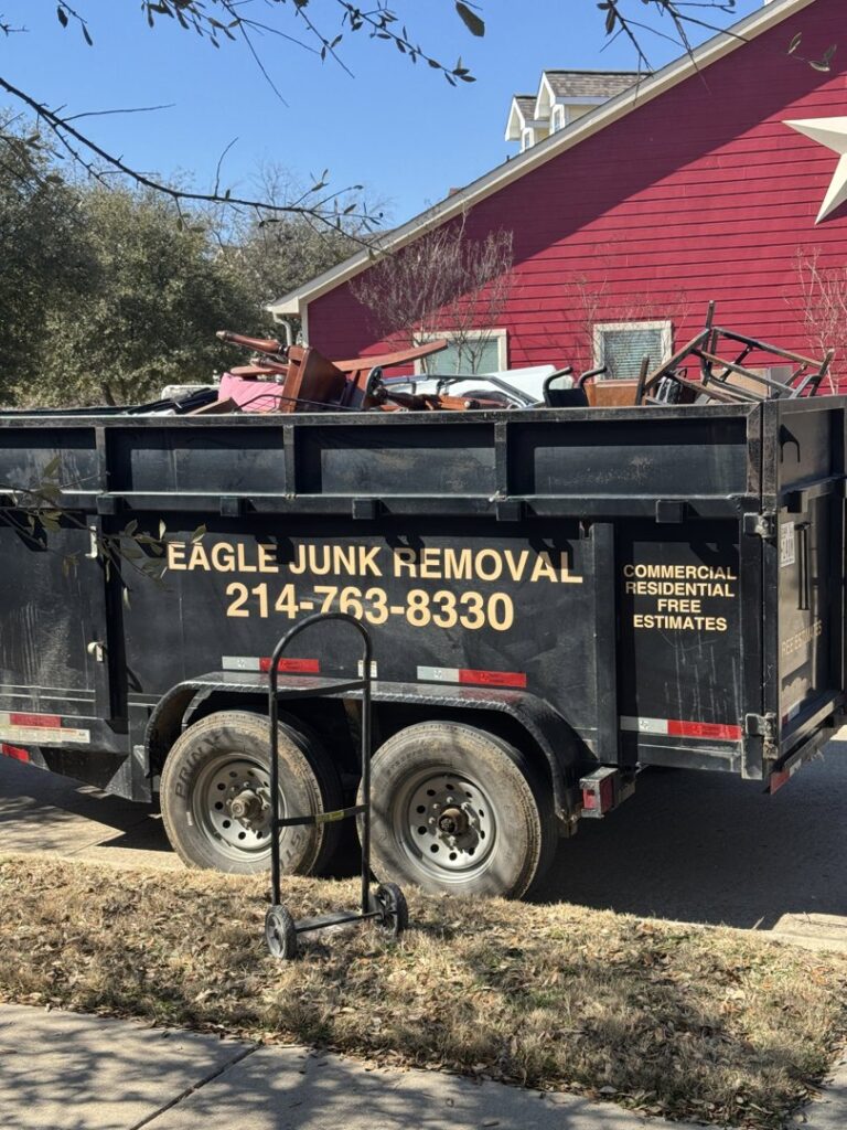 A junk removal trailer from Eagle Junk Removal in Fort Worth, TX, filled with furniture and construction debris.