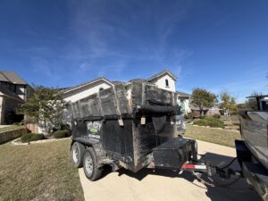 A City to City Junk Removal trailer filled with debris and junk in a residential driveway in Fort Worth, TX.