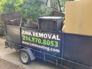 A Lolo Hauling Junk Removal trailer loaded with furniture and other items for disposal in Dallas, TX.