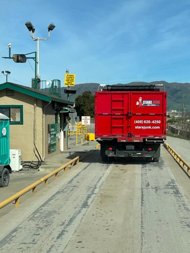A Stars Junk Removal truck at a weigh station or landfill entrance, part of the disposal process in San Jose, CA