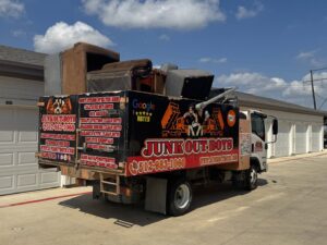 A Junk Out Boyz LLC truck loaded with old furniture and mattresses after a junk removal job in Austin, TX.